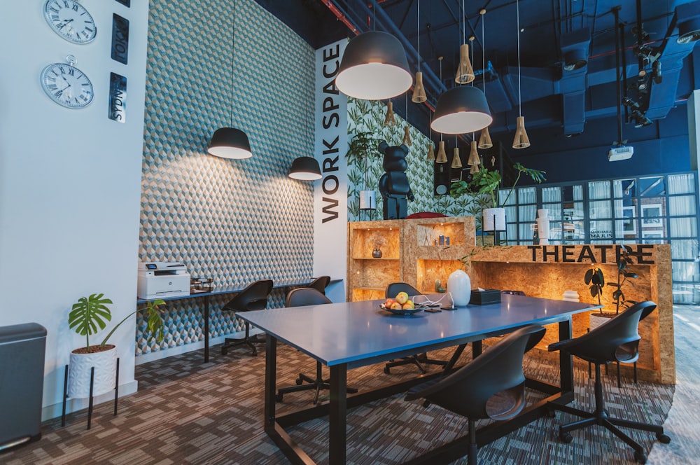 a room with a table, chairs and a clock on the wall