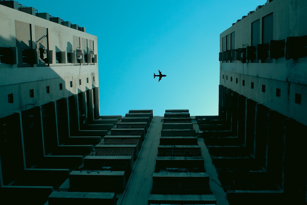 an airplane flying in the sky between two buildings