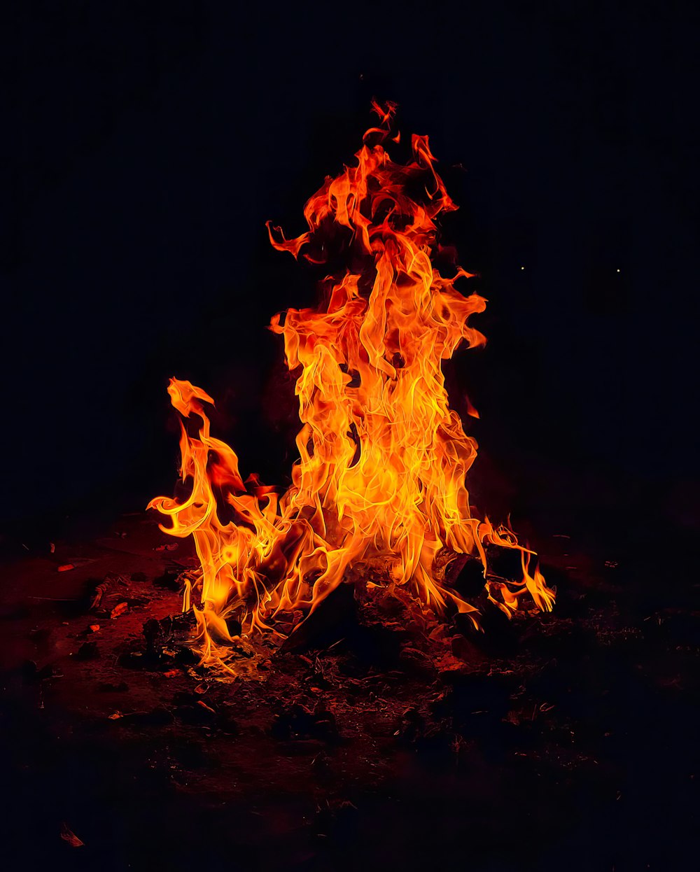 a fire blazing in the dark on a black background