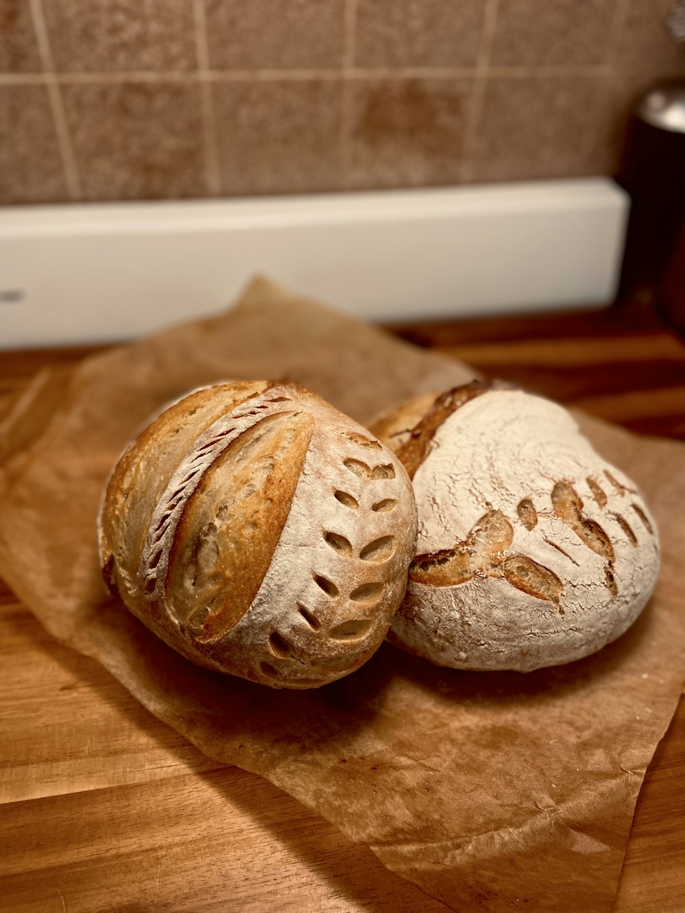 two loaves of bread sitting on top of a wooden table