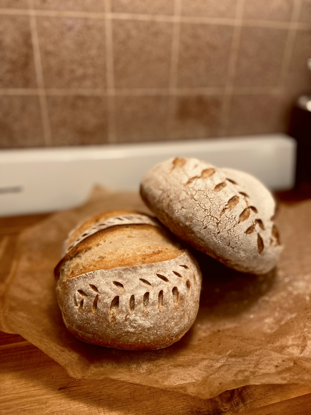 two loaves of bread sitting on a cutting board