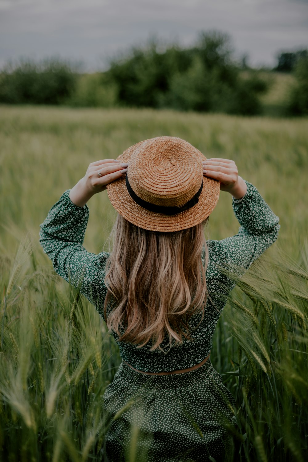 a woman standing in a field of tall grass