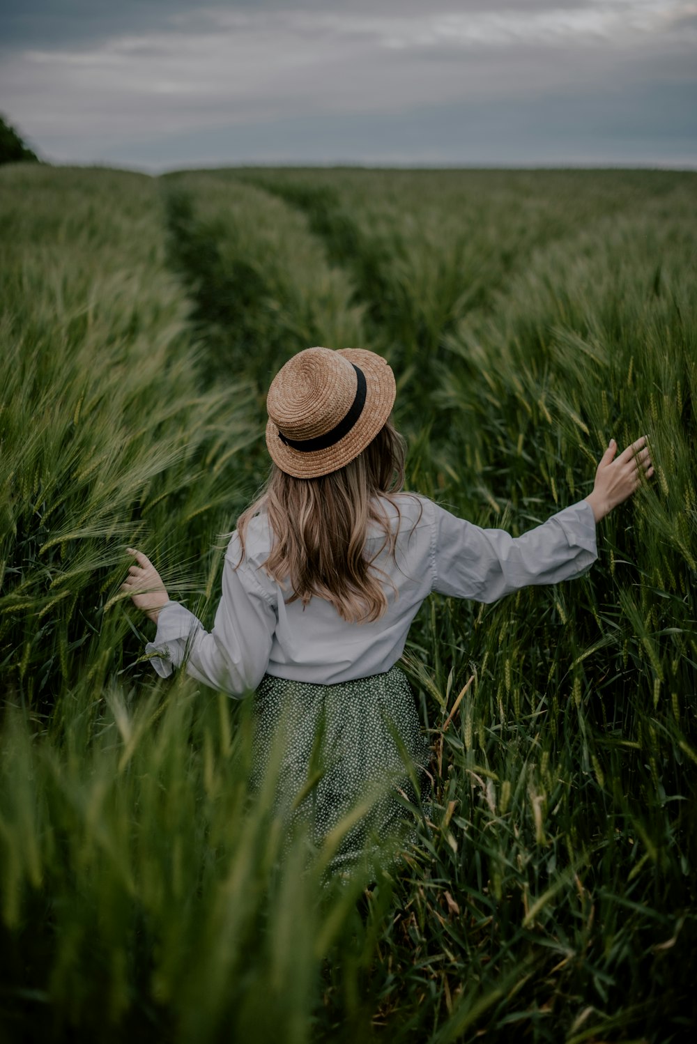 a woman standing in a field of tall grass