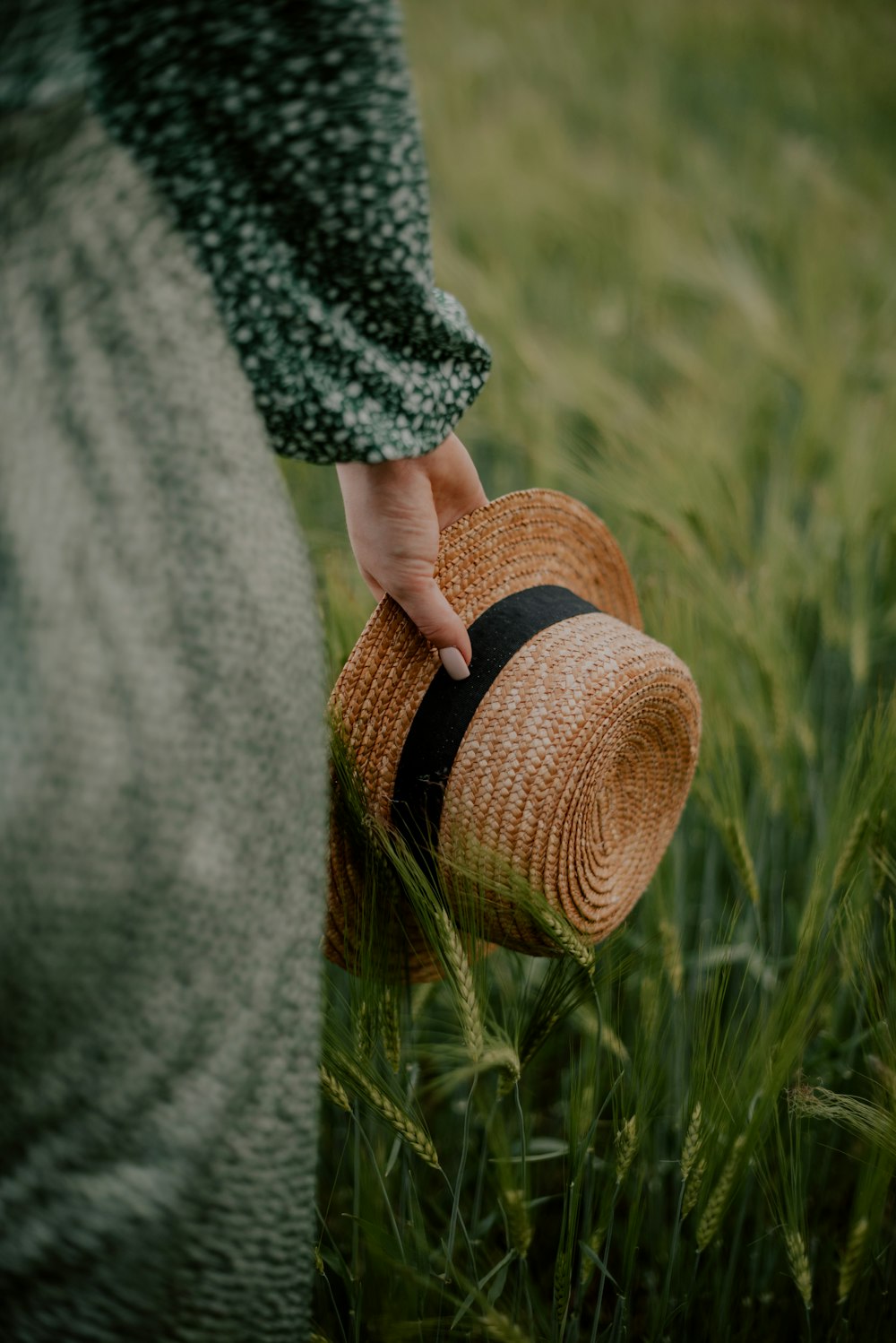 a person standing in a field with a hat