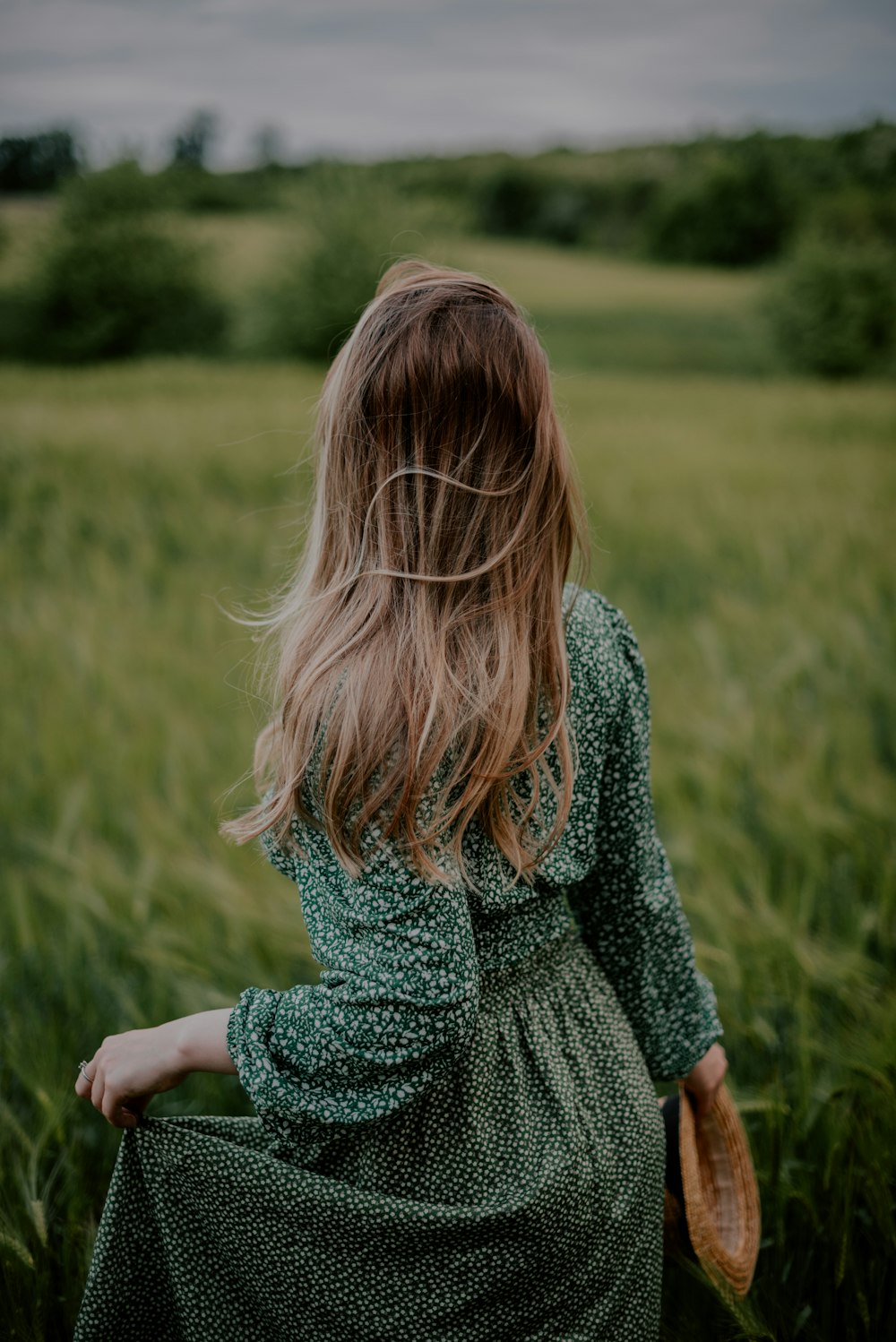 a woman standing in a field of tall grass