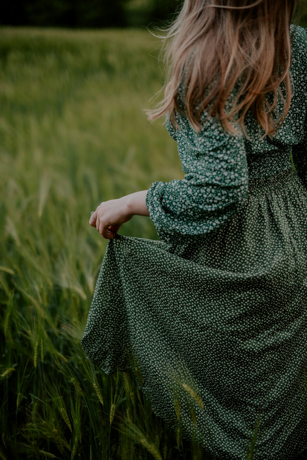 a woman standing in a field of tall grass