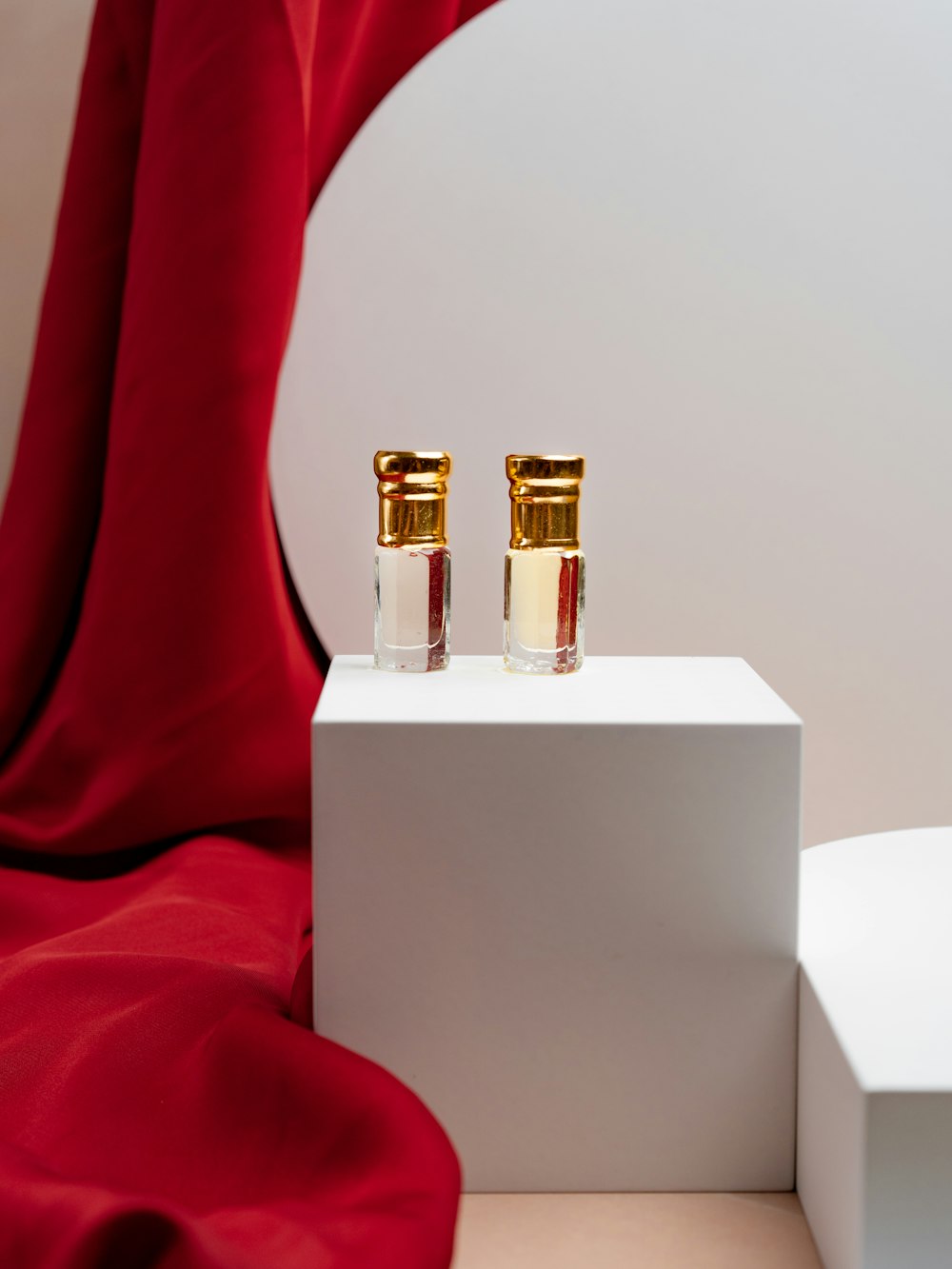 a pair of perfume bottles sitting on top of a white box