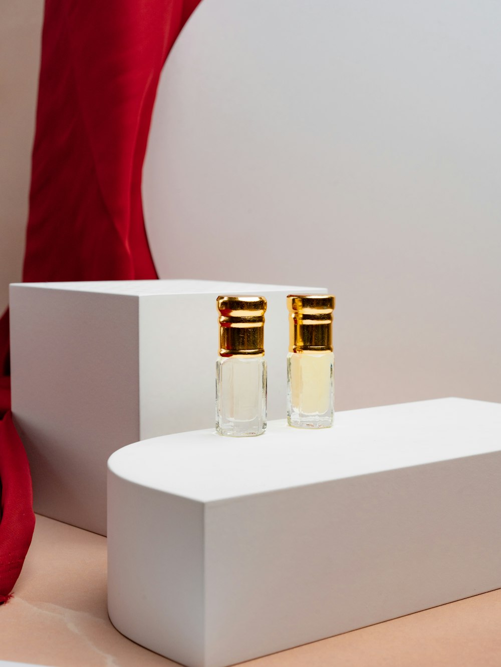 a pair of perfume bottles sitting on top of a white box