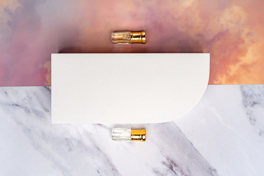 a pair of gold bullet plugs sitting on top of a white piece of paper