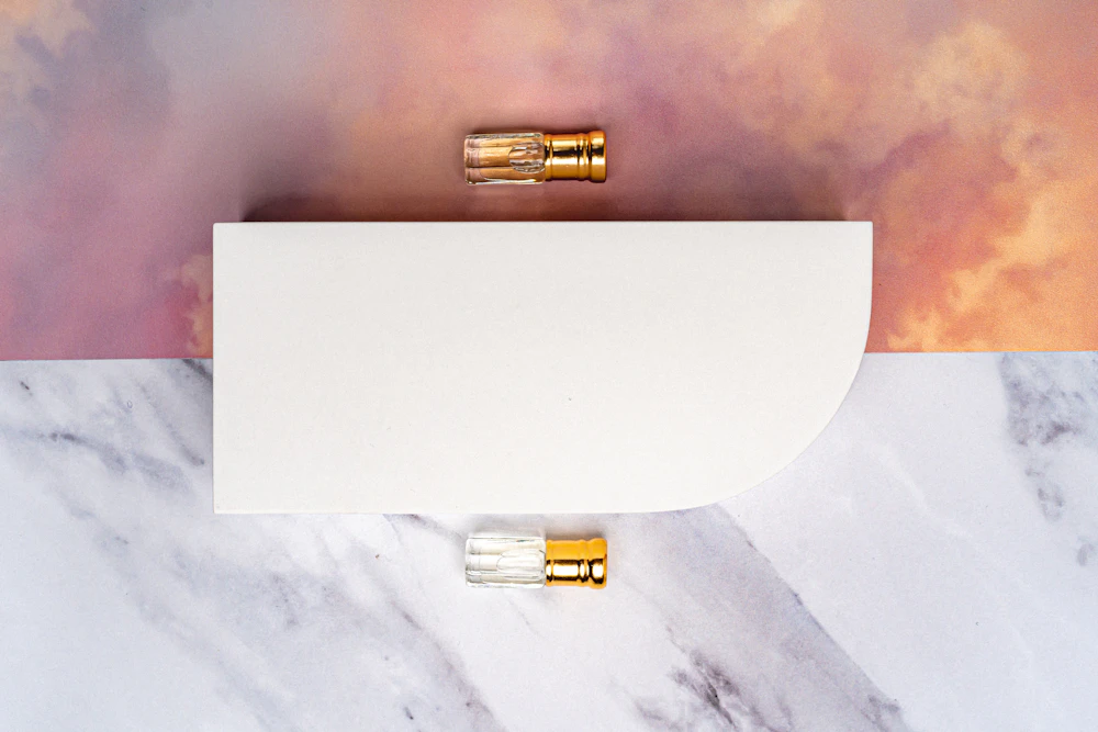 Two gold-capped glass vials on a white arch