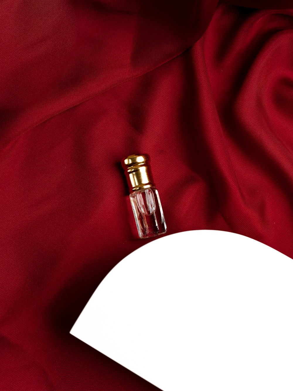 a bottle of perfume sitting on top of a red cloth