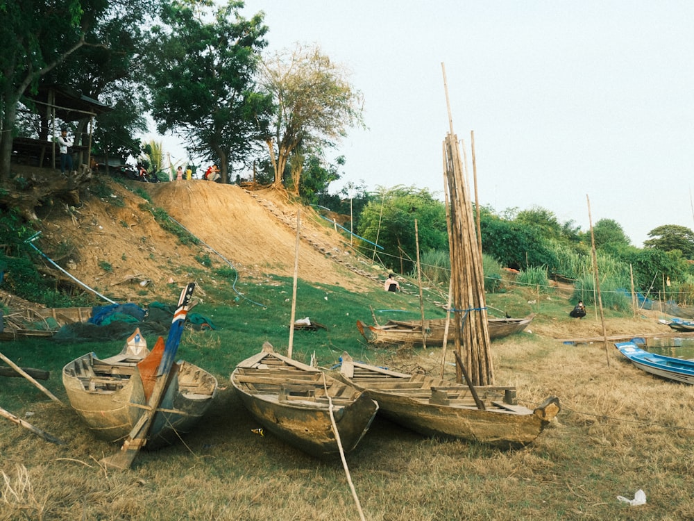 a group of boats sitting on top of a grass covered field