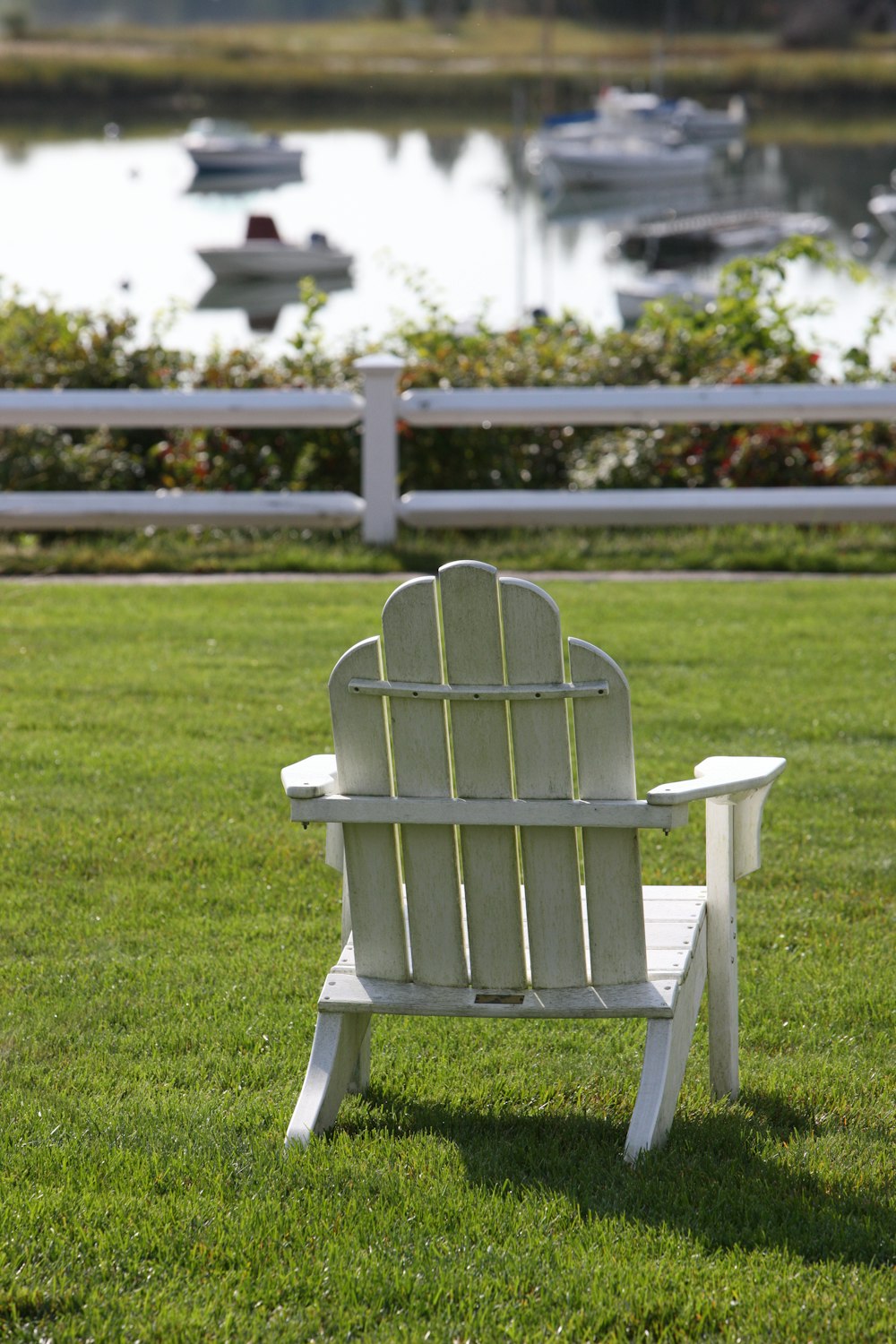 a white chair sitting on top of a lush green field