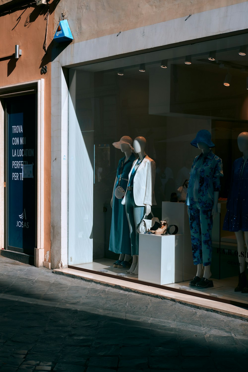 two mannequins in a window display in front of a store