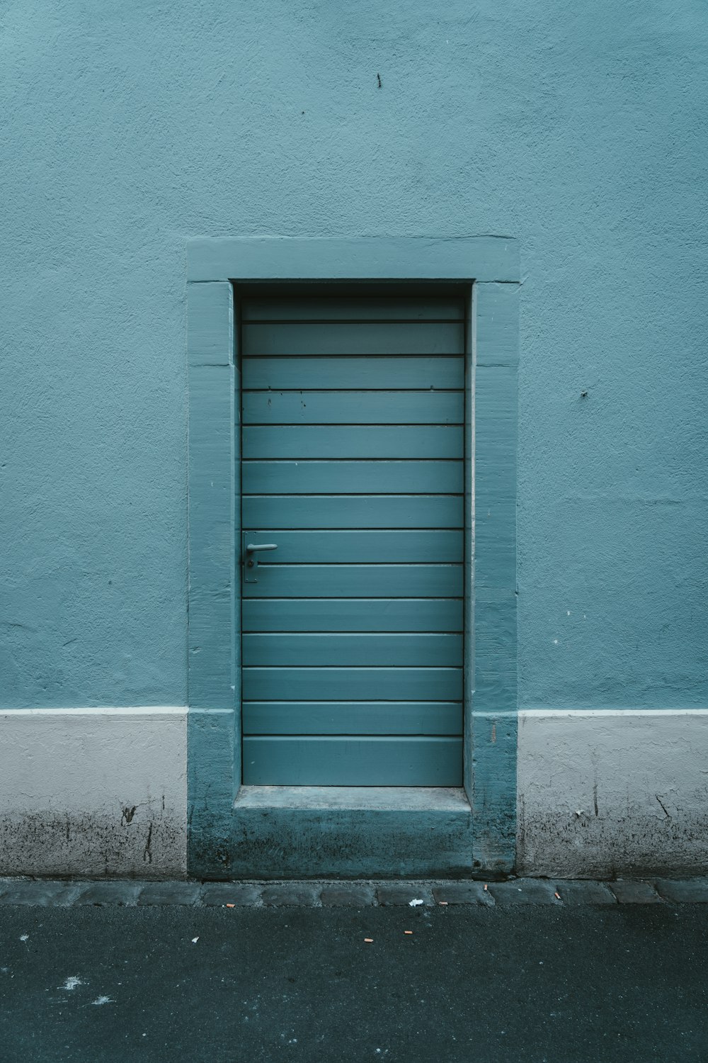 a closed blue door on a blue wall