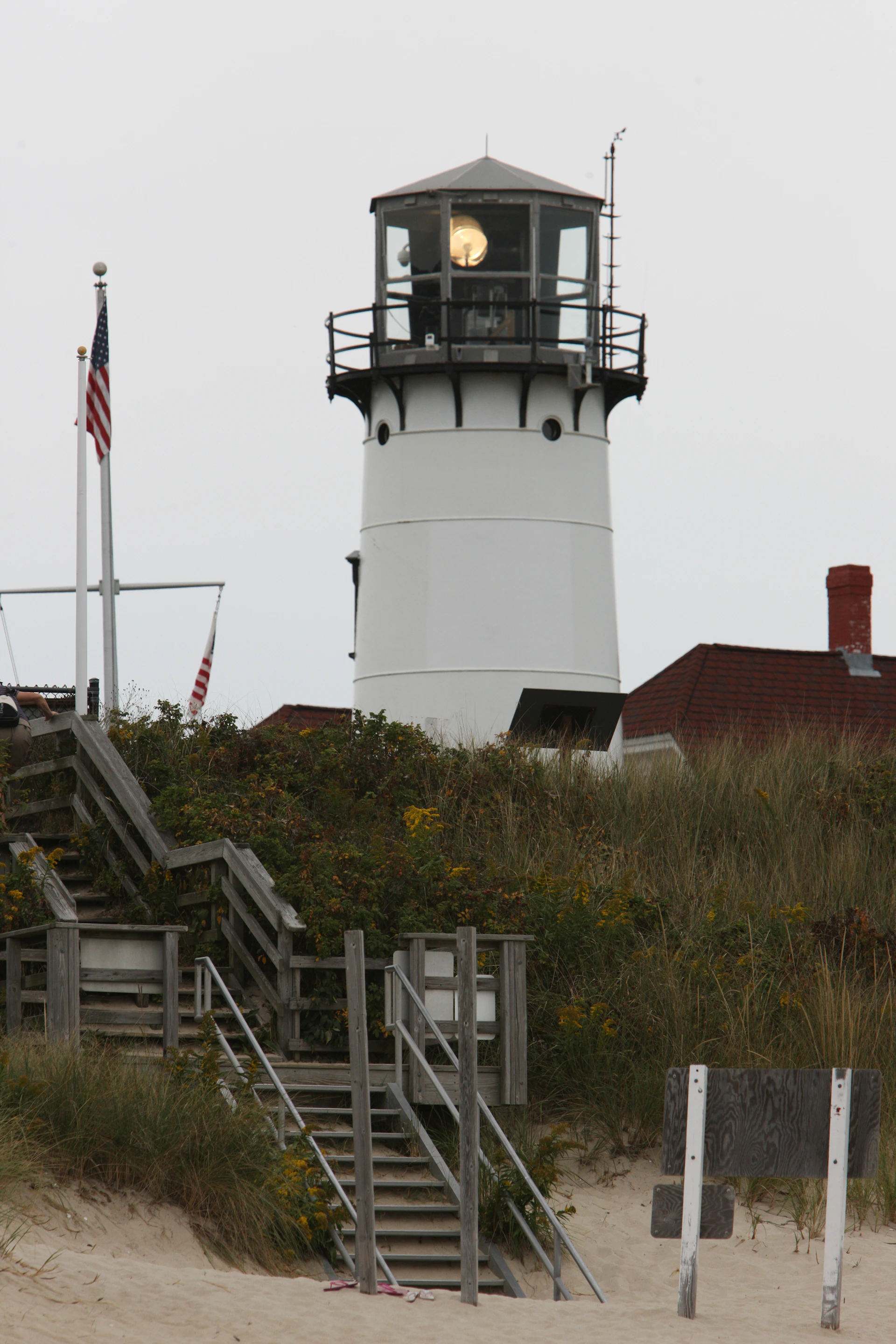 a lighthouse on top of a hill next to a beach