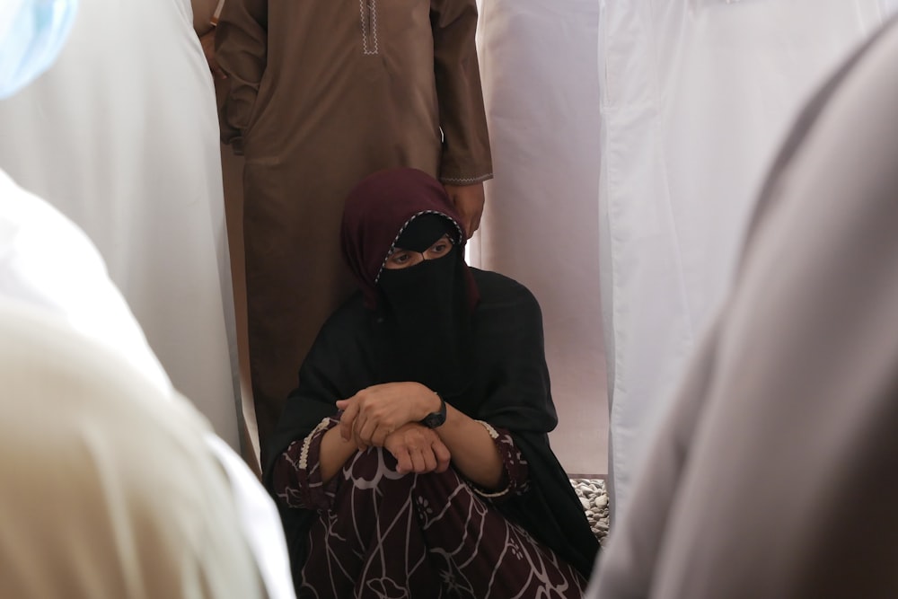 a woman sitting on the ground in front of a group of people