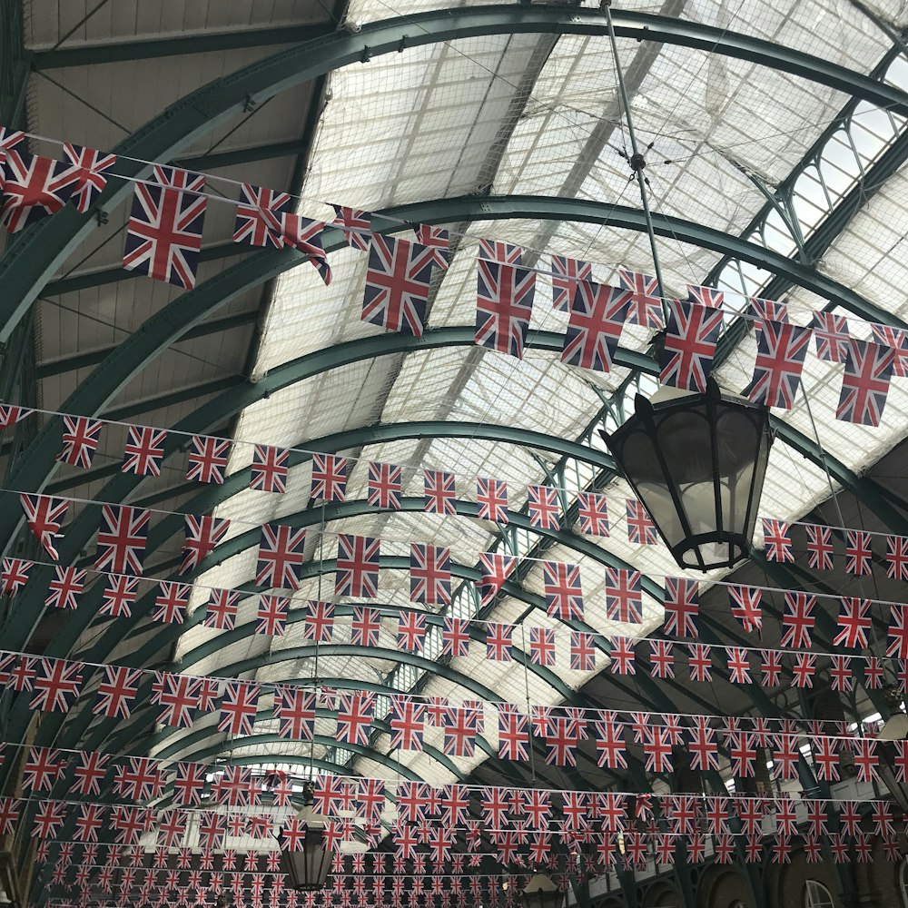 a train station with a lot of flags hanging from the ceiling