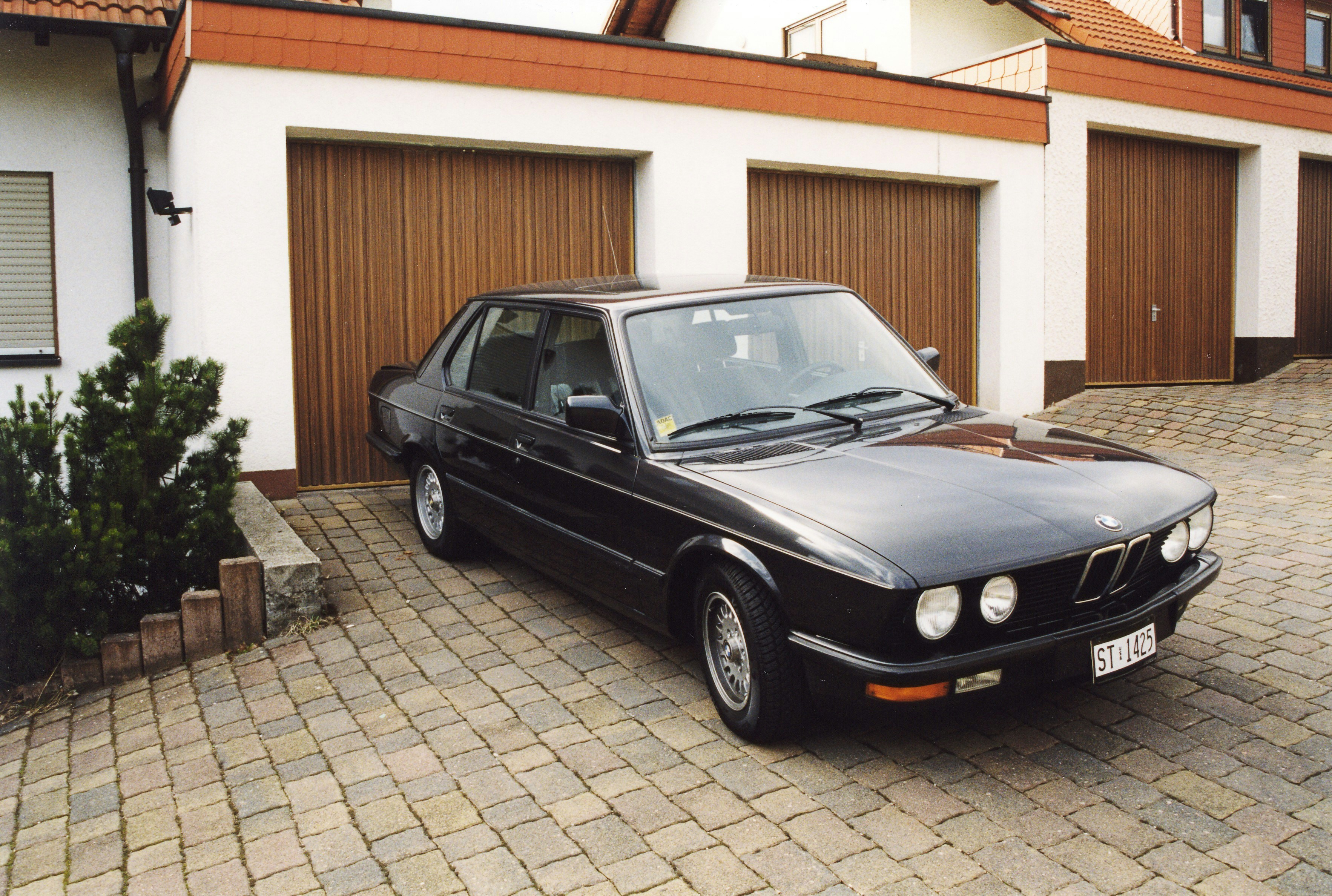 a black car parked in front of a house