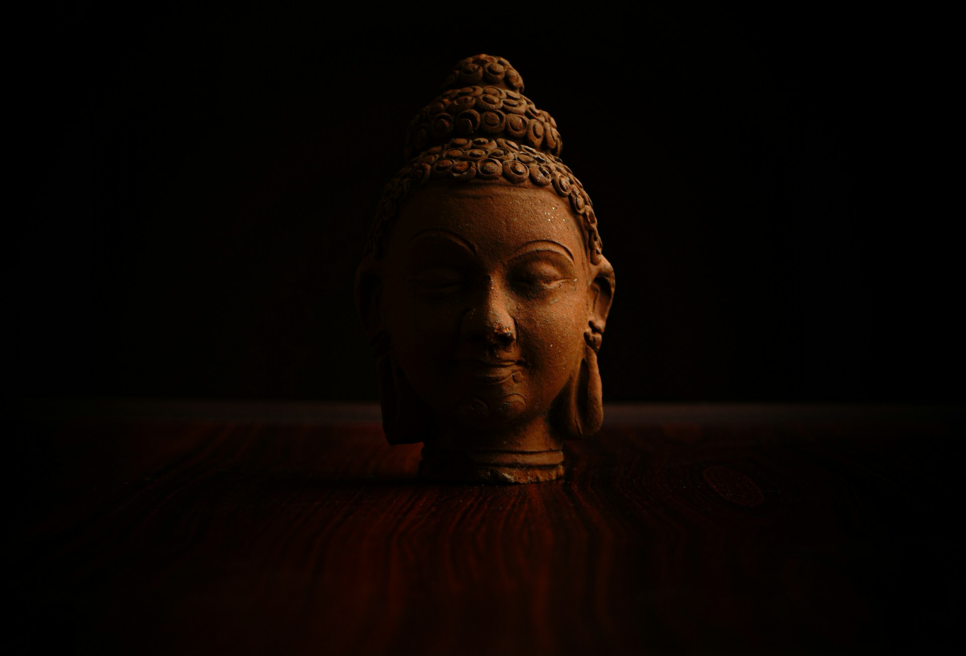 a buddha statue sitting on top of a wooden table