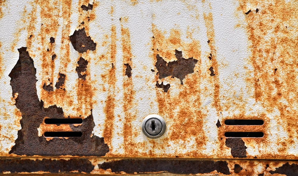 an old rusted metal door with a button on it