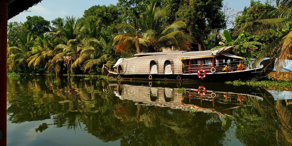 a house boat on a river surrounded by palm trees