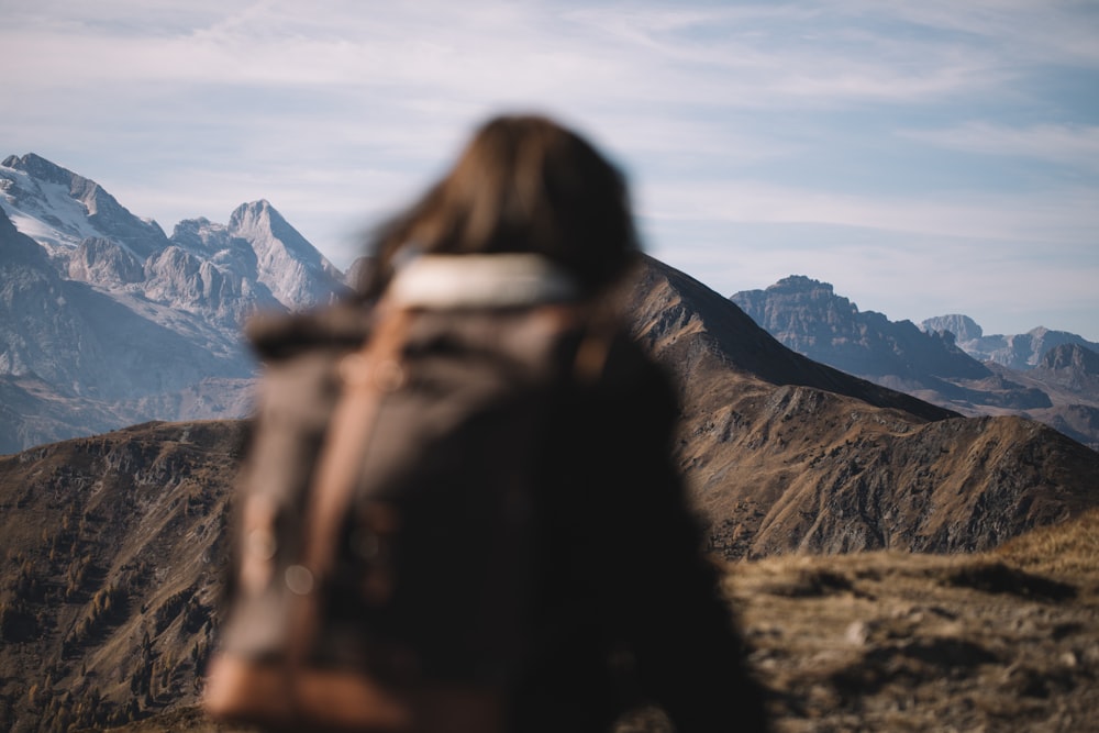 a person with a backpack looking at a mountain range