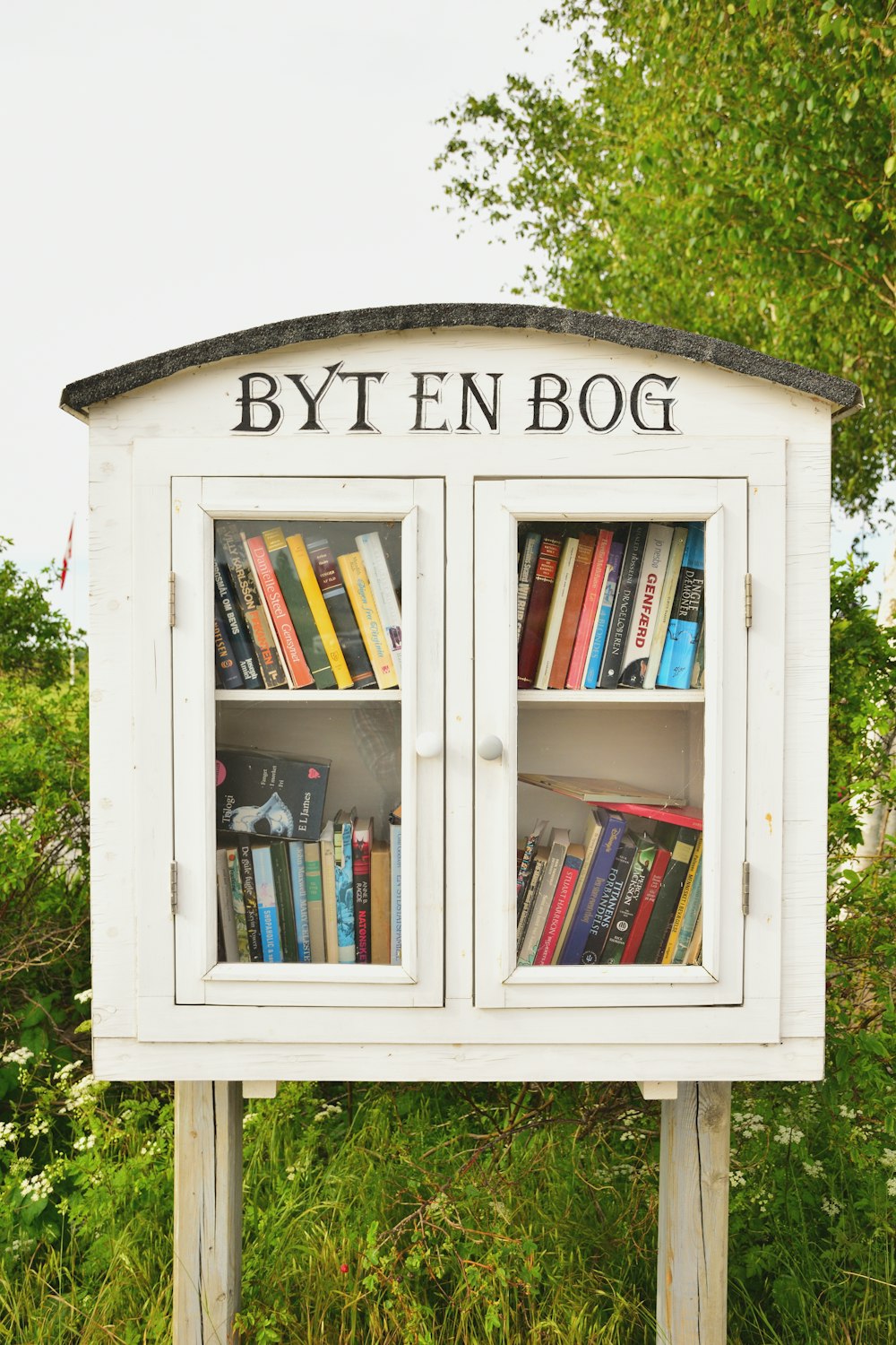 a white book case with books inside of it