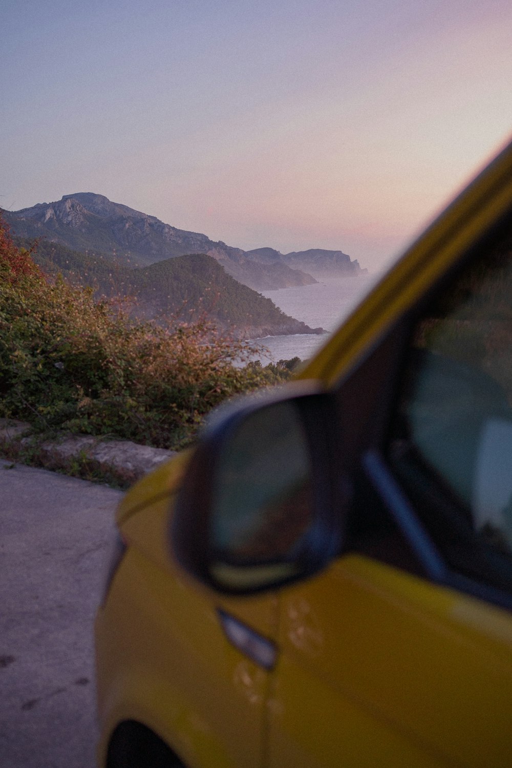 a yellow car parked on the side of a road