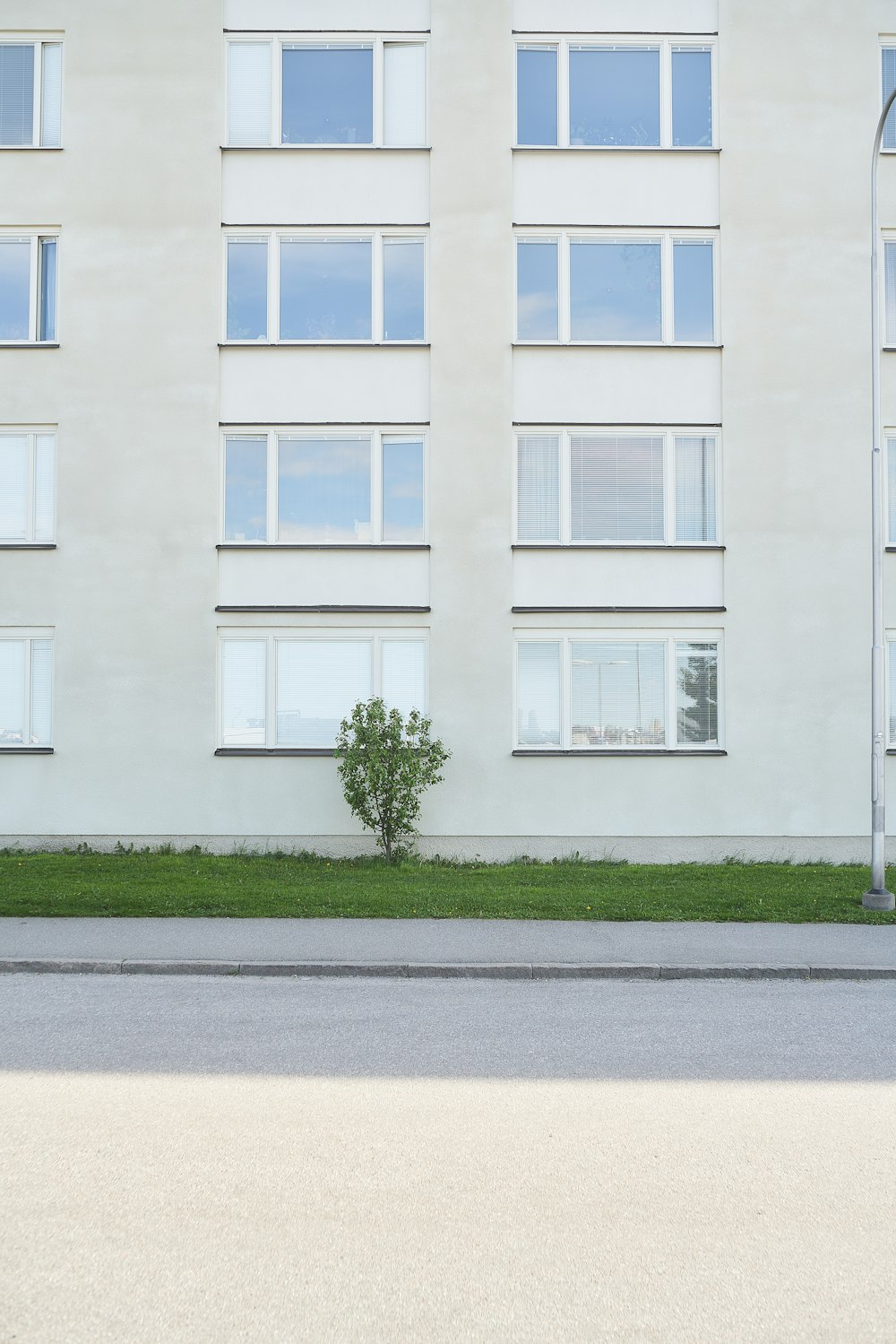 a tall white building sitting next to a street