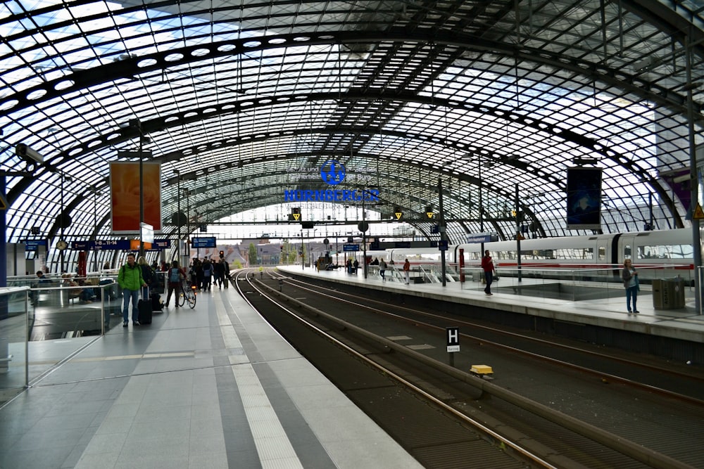 a train station with people waiting for the train