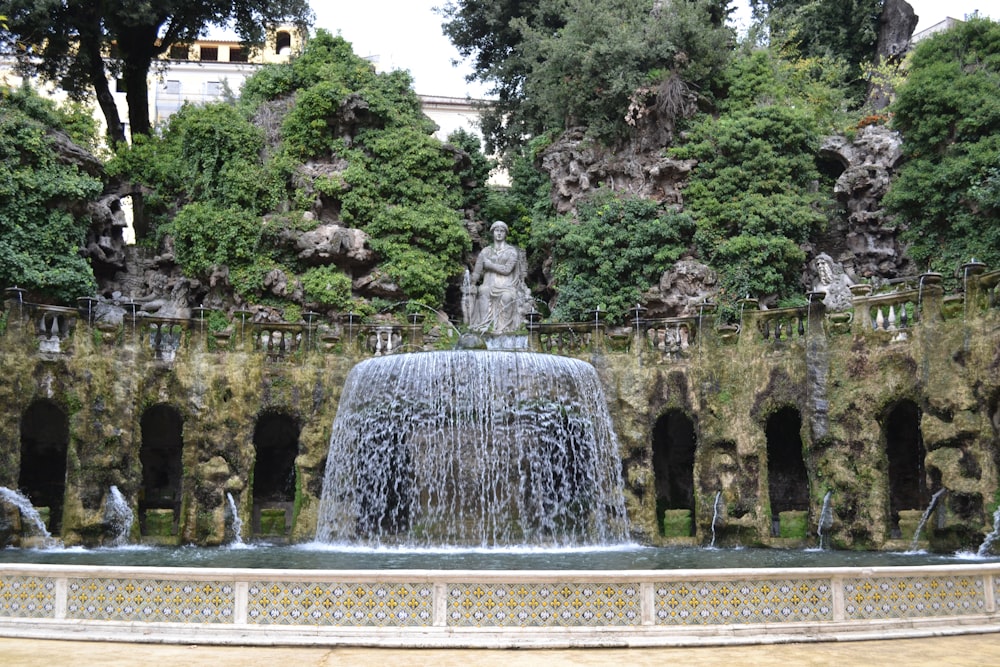 une fontaine avec une statue au milieu
