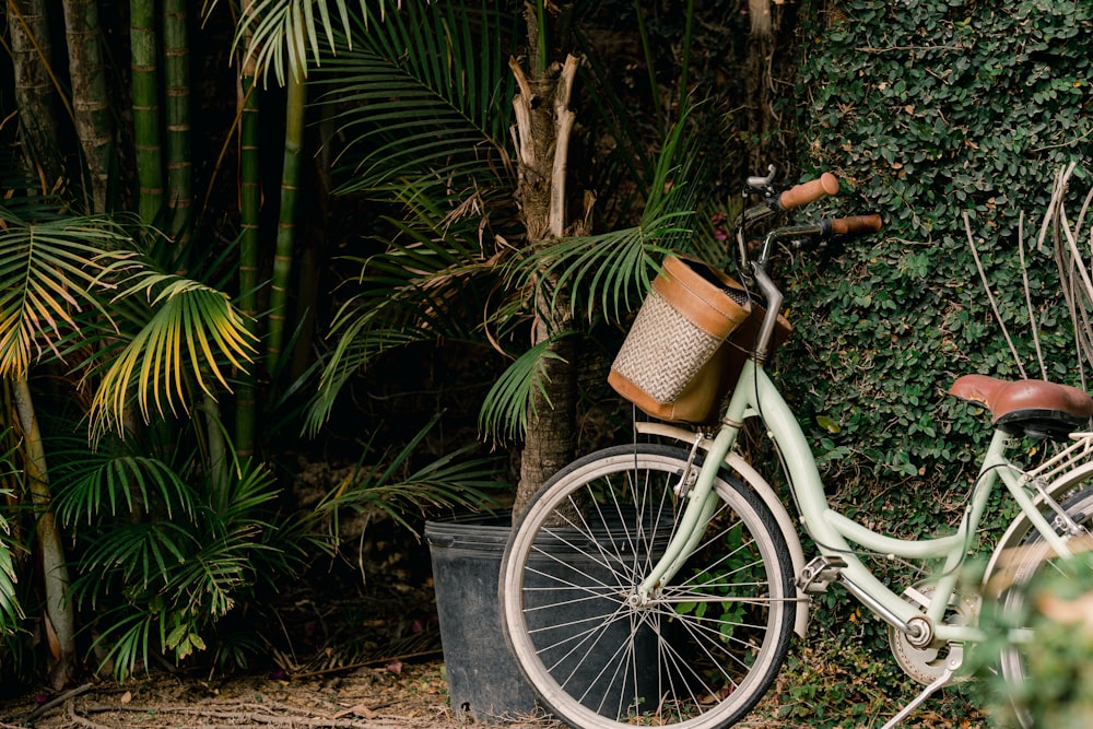 a bicycle parked next to a wall covered in plants