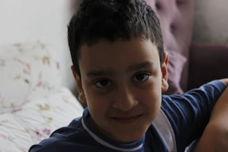 A smiling teenager sitting in a cozy room, engaged in a life coaching session.