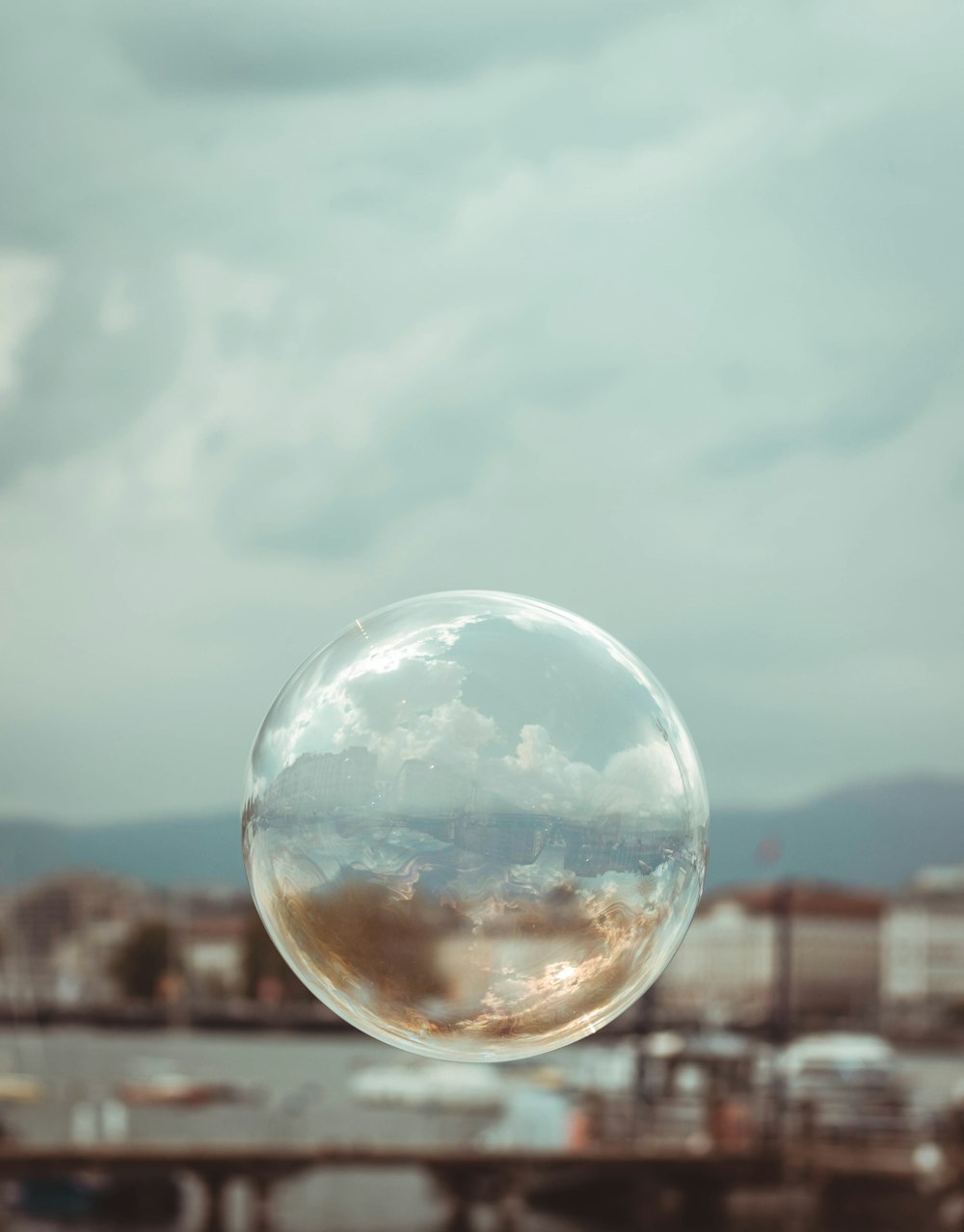 a bubble floating in the air with a cloudy sky in the background