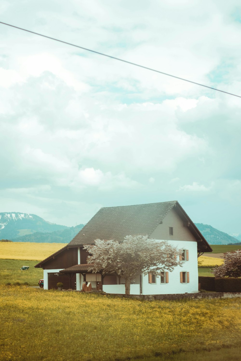 a house in a field with mountains in the background