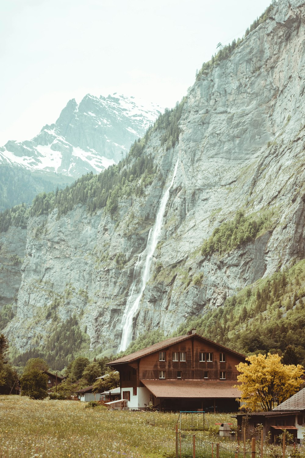 a house in a field with a waterfall in the background