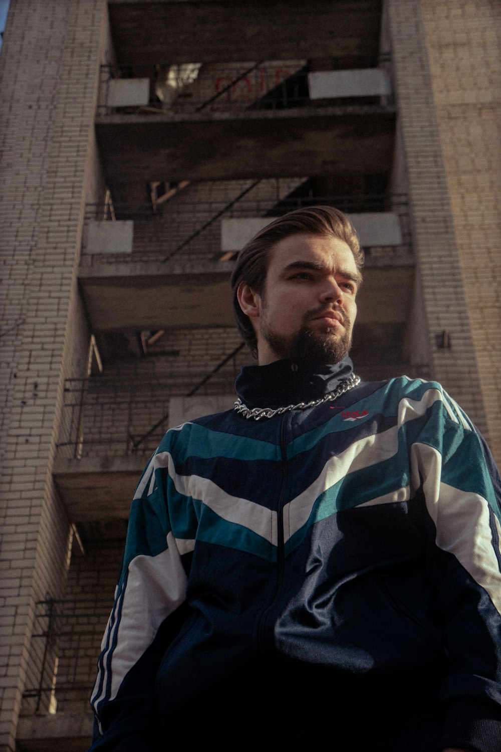 a man sitting on a chair in front of a tall building