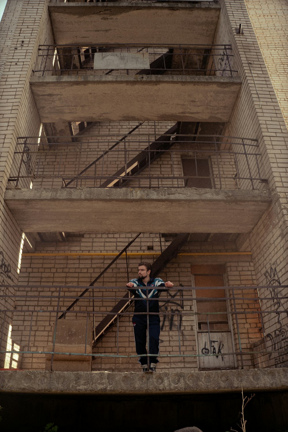 a man standing on the balcony of a tall building