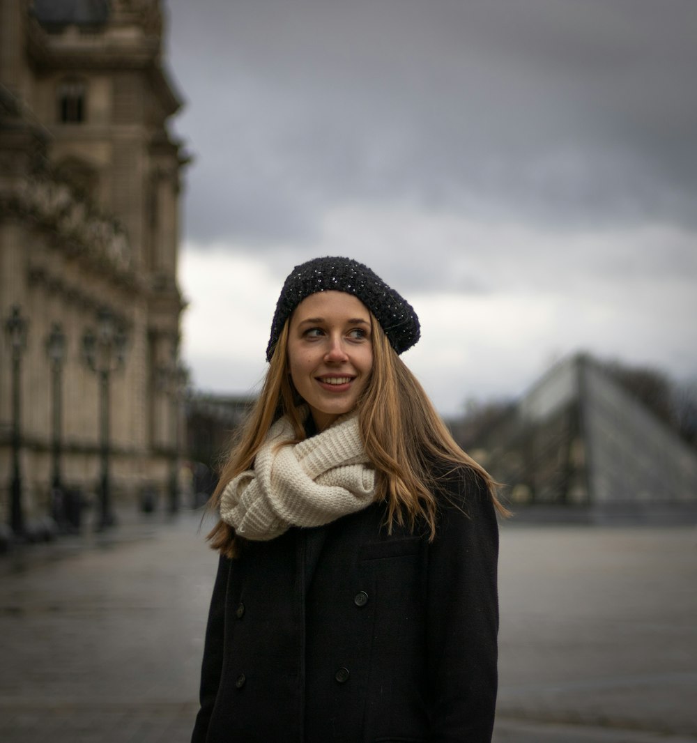 a woman wearing a black coat and a white scarf