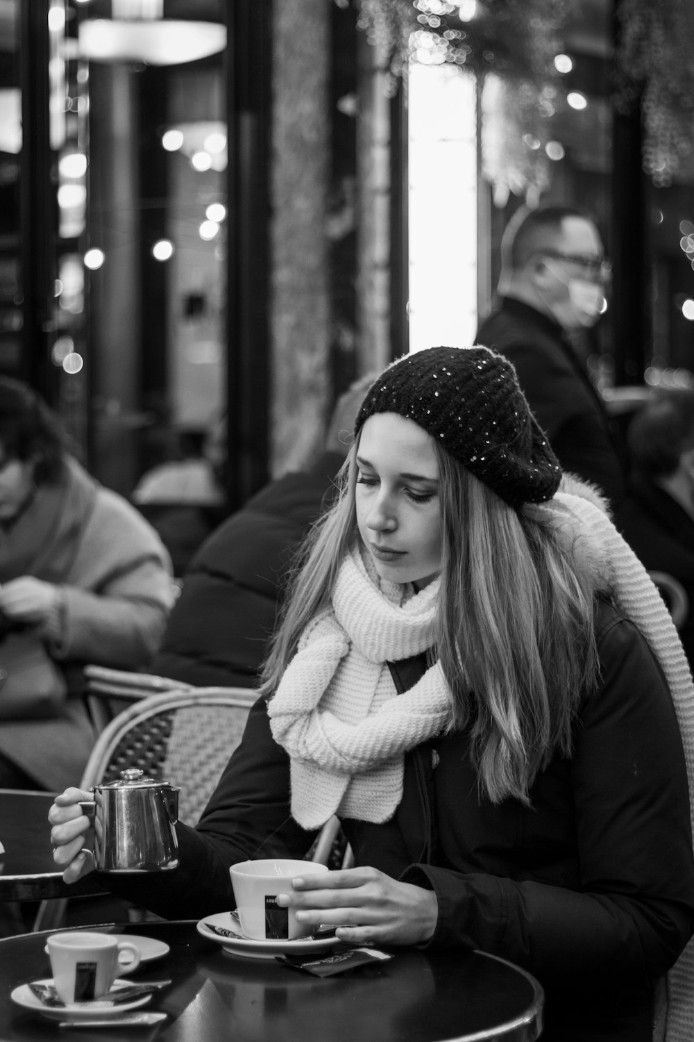 a woman sitting at a table with a cup of coffee