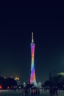 Dynamic tower lighting illuminating an outdoor event, casting vibrant colors over a lively crowd.