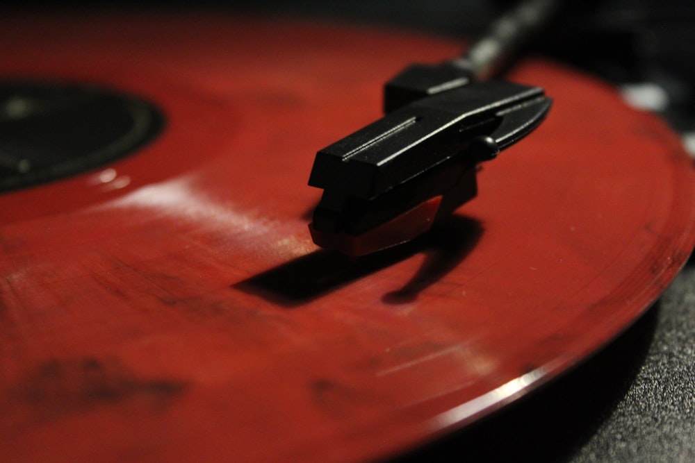 a close up of a red and black turntable