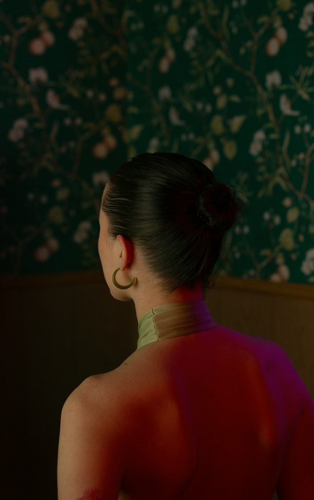 uma mulher em um vestido vermelho olhando para um papel de parede