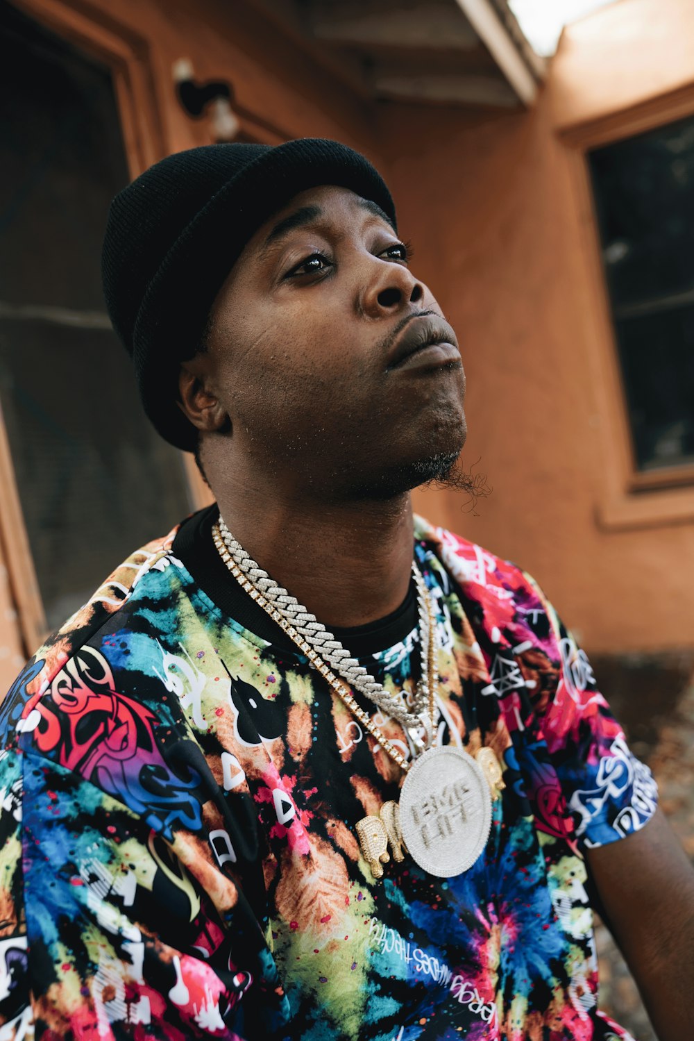 a man wearing a colorful shirt and a black hat