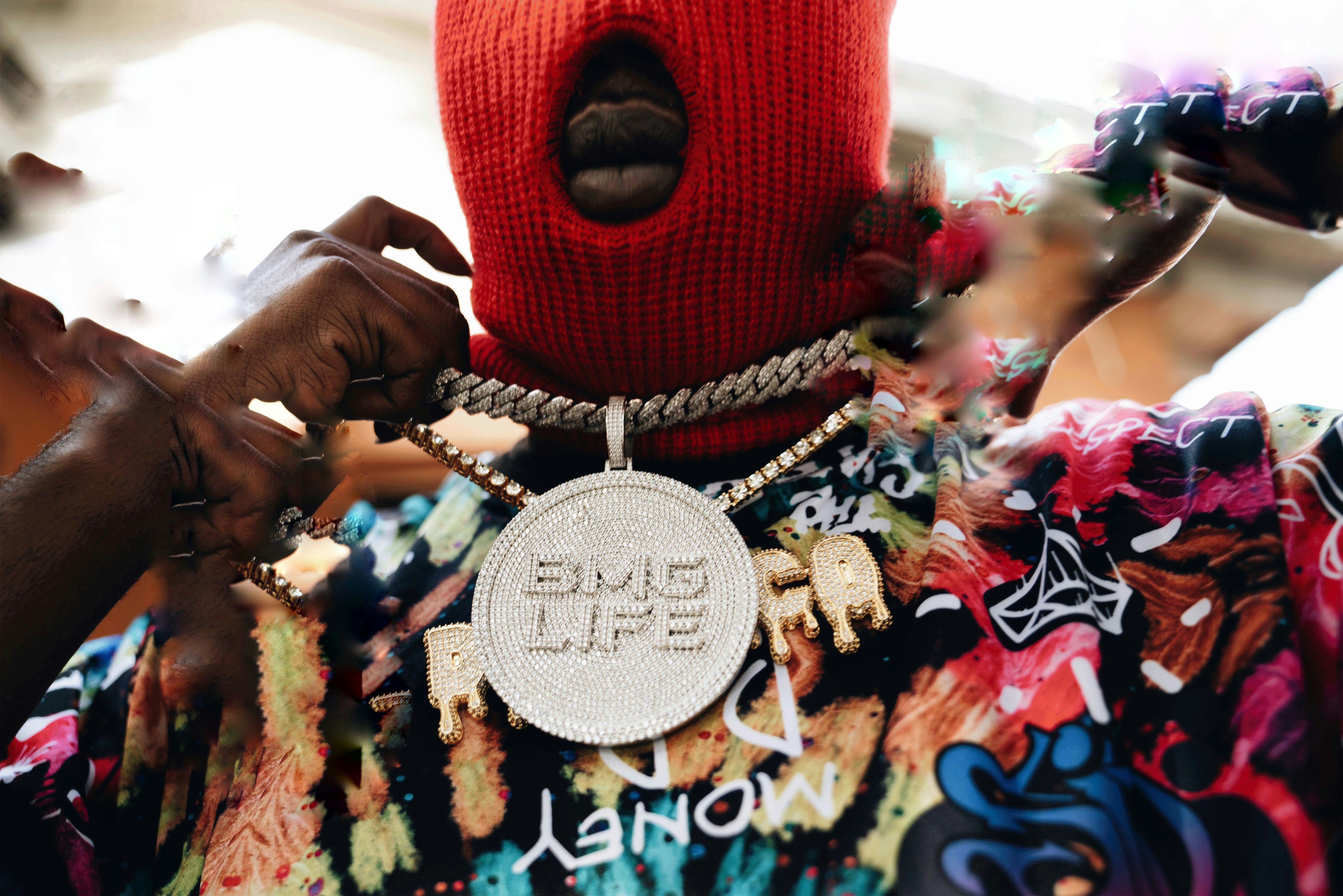 Une personne portant un masque rouge festif et un collier lors d un événement culturel vibrant à Miami