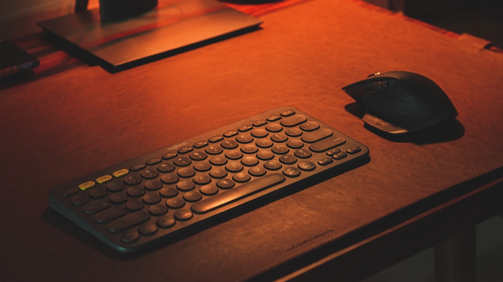 a computer keyboard and mouse sitting on a desk