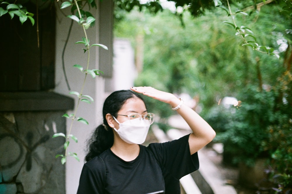 a woman wearing a face mask and reading a book