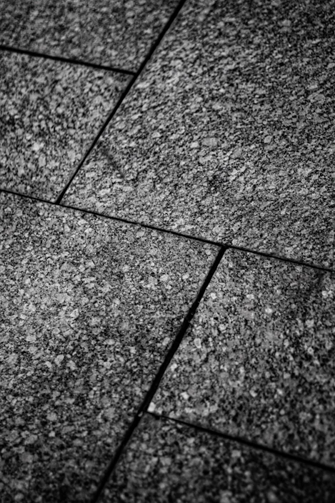 Close-up of textured stone tiles arranged in a modern floor pattern with warm lighting