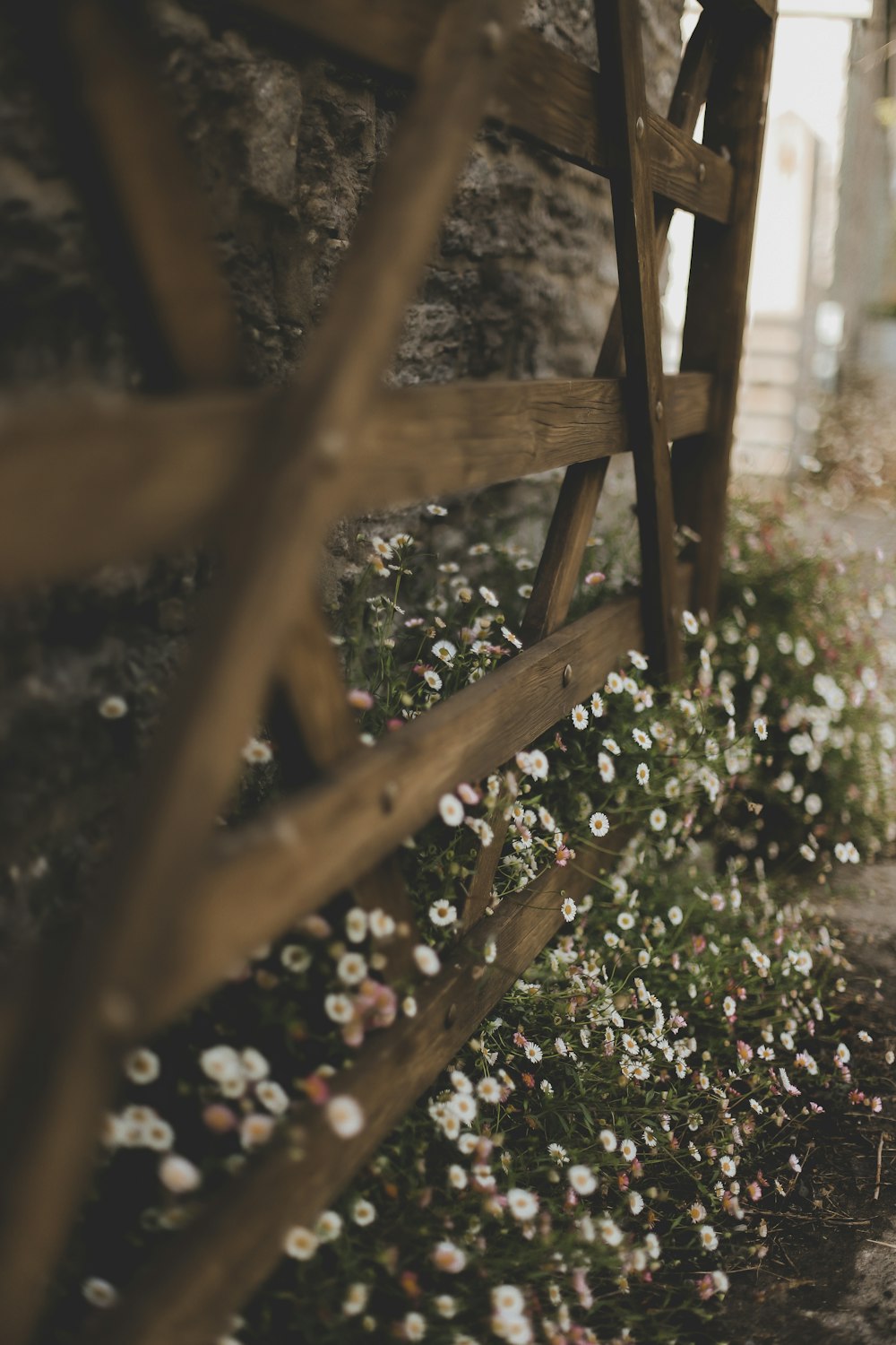 a wooden bench sitting next to a stone wall